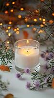 Blank clear straight candle glass amidst a setting with delicate fairy lights photo
