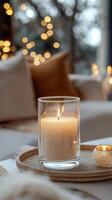 Blank clear straight candle glass amidst a setting with a plush pillow, a scented diffuser, and delicate string lights, modern warm bedroom mockup, serene and stylish photo