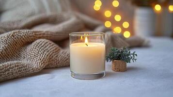 Blank clear straight candle glass surrounded by a stack of books, a small vase with flowers, and warm ambient lighting, modern warm bedroom mockup, chic and cozy photo