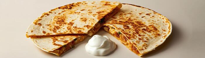 Delicious cheesy quesadilla served with creamy sour cream on a neutral background. Perfect for food photography and culinary presentations. photo