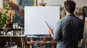 Creative artist standing in front of a new white canvas on an easel, brush in hand, ready to start painting, modern art studio, focused and inspired photo