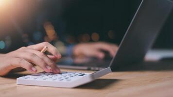 Businessman using a calculator to calculate numbers ,profit and loss statement review of company performance , effective tax deduction planning for individuals and companies paying tax rates photo