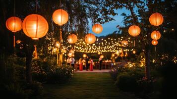 Brightly lit Chinese lanterns hanging from trees in a night garden. Mid-Autumn festival decorations photo