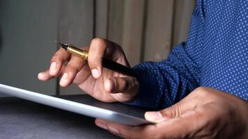 Young man working on digital tablet at office desk, video