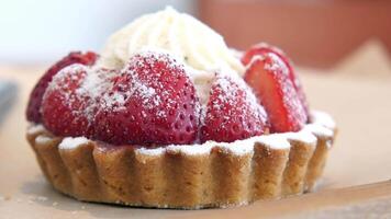 Indulge in a Delicious Strawberry Tart topped with Whipped Cream and a Dusting of Powdered Sugar video