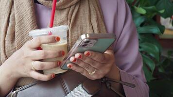 Enjoying a casual coffee break while engaging in friendly phone interactions at a cozy cafe video