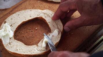The delightful act of spreading creamy cream cheese generously on a fresh, warm bagel video