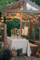 decorated greenhouse in trendy wedding setting with dinner table, candles and candle lights. photo
