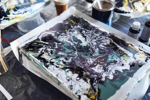 The process of creating a painting with acrylic paints. Abstract background. Acrylic Fluid Pouring. Painting tutorial or master class. photo