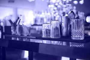 Bar counter with bottles in blurred violet background photo