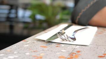 Elegant dining setup with cutlery on wooden table in sunlit cafeteria, creating warm ambiance video