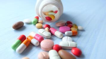 close up of colorful pills spilling on blue background video