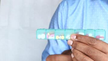 man's hands taking medicine from a pill box video