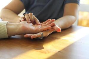 Woman visiting palmistry expert, fortune teller reading future, analyzing life lines on palm photo