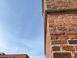Clear blue sky with brick wall. Red brick wall texture background. Brick wall background photo