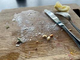 The wooden tray is dirty due to eating marks with a fork and knife and lemon on it photo