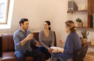 Couple visiting a psychologist and having a psychological session while dealing with problems in relationships together photo