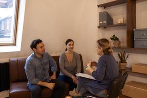Couple visiting a psychologist and having a psychological session while dealing with problems in relationships together photo