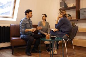 Couple visiting a psychologist and having a psychological session while dealing with problems in relationships together photo