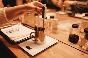 Master class of creating candles. Closeup of woman hand measuring temperature of melted wax. photo