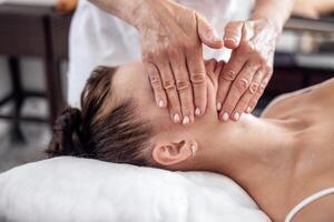 Brunette girl closed her eyes and enjoys a spa procedure in beauty salon photo