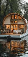 Modern floating house on calm water surrounded by trees. photo