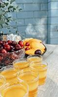 a table with a bowl of fruit and a bowl of juice photo