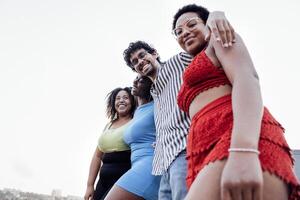 Four smiling mixed race friends standing and looking down at camera photo