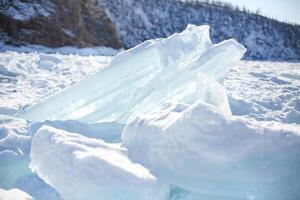 Pieces of ice lying on the ideal smooth ice of baikal with ice hummocks in the horizon photo