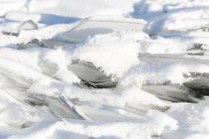 Pieces of ice lying on the ideal smooth ice of baikal with ice hummocks in the horizon photo