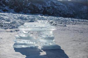 Pieces of ice lying on the ideal smooth ice of baikal with ice hummocks in the horizon photo