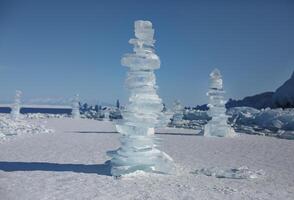 Pieces of ice lying on the ideal smooth ice of baikal with ice hummocks in the horizon photo