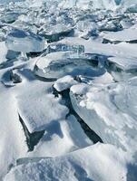 Pieces of ice lying on the ideal smooth ice of baikal with ice hummocks in the horizon. photo