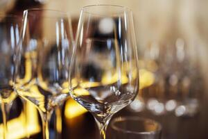 Extrime closeup of empty champagne glasses in a row. Wine goblet at wedding reception, alcohol bar, catering in restaurant. photo