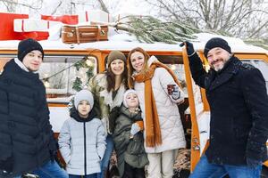 Happy family of travelers in minivan lying together at open rear doors and smiling at camera photo