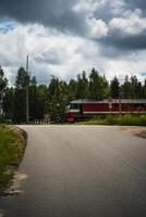 The train is standing in front of a railway crossing. Cloudy sky photo