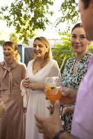 Group of beautiful happy people communicating and smiling while spending time on weding outdoors part photo