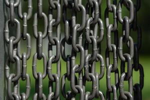 Chains background. Vertically hanging chains on a lawn background photo