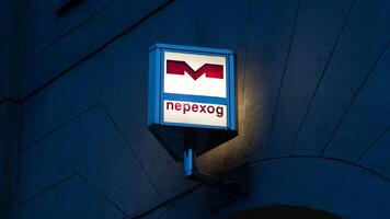 M, Transition. The subway crossing. Illuminated subway sign in the evening photo