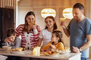 Big happy family is having lunch in dining room. Parents and children are having fun at home photo