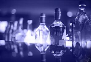 Bar counter with bottles in blurred violet background photo