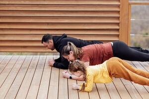 a man and woman doing push ups with a child photo