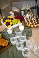 Swiss table at the party. Close up of croissants with greens and glasses with drinks photo