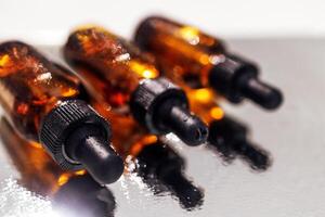 Group of bottles with drops on them and their reflection on a mirror surface photo