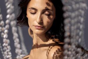 Natural young woman with clean skin in sunlight with shadows on face photo