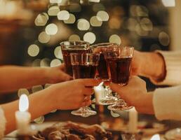 Family friends have fun together in winter eating food on a wooden table photo