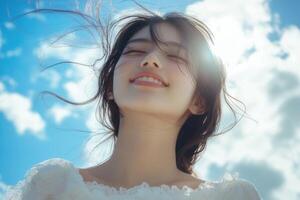 Beautiful woman smiling hair blowing in the wind blue sky background. photo