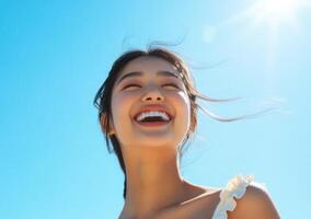 Beautiful woman smiling hair blowing in the wind blue sky background. photo