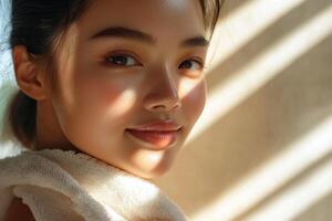 A beautiful woman with delicate skin a white towel wrapped around her shoulders. photo