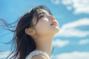 Beautiful woman smiling hair blowing in the wind blue sky background. photo